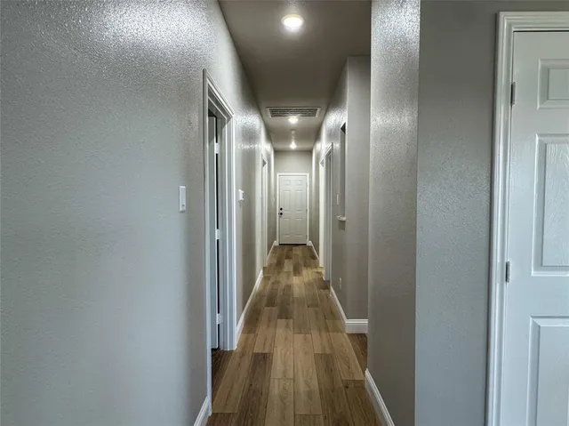 a view of a hallway with wooden floor