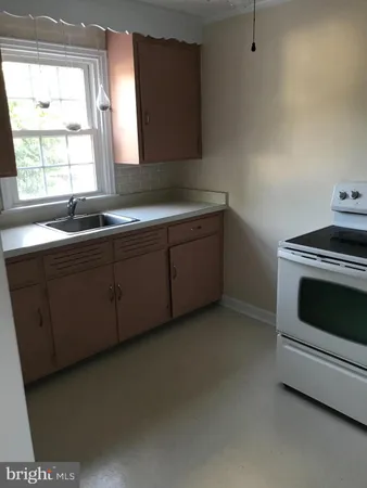 a kitchen with granite countertop white cabinets and a sink