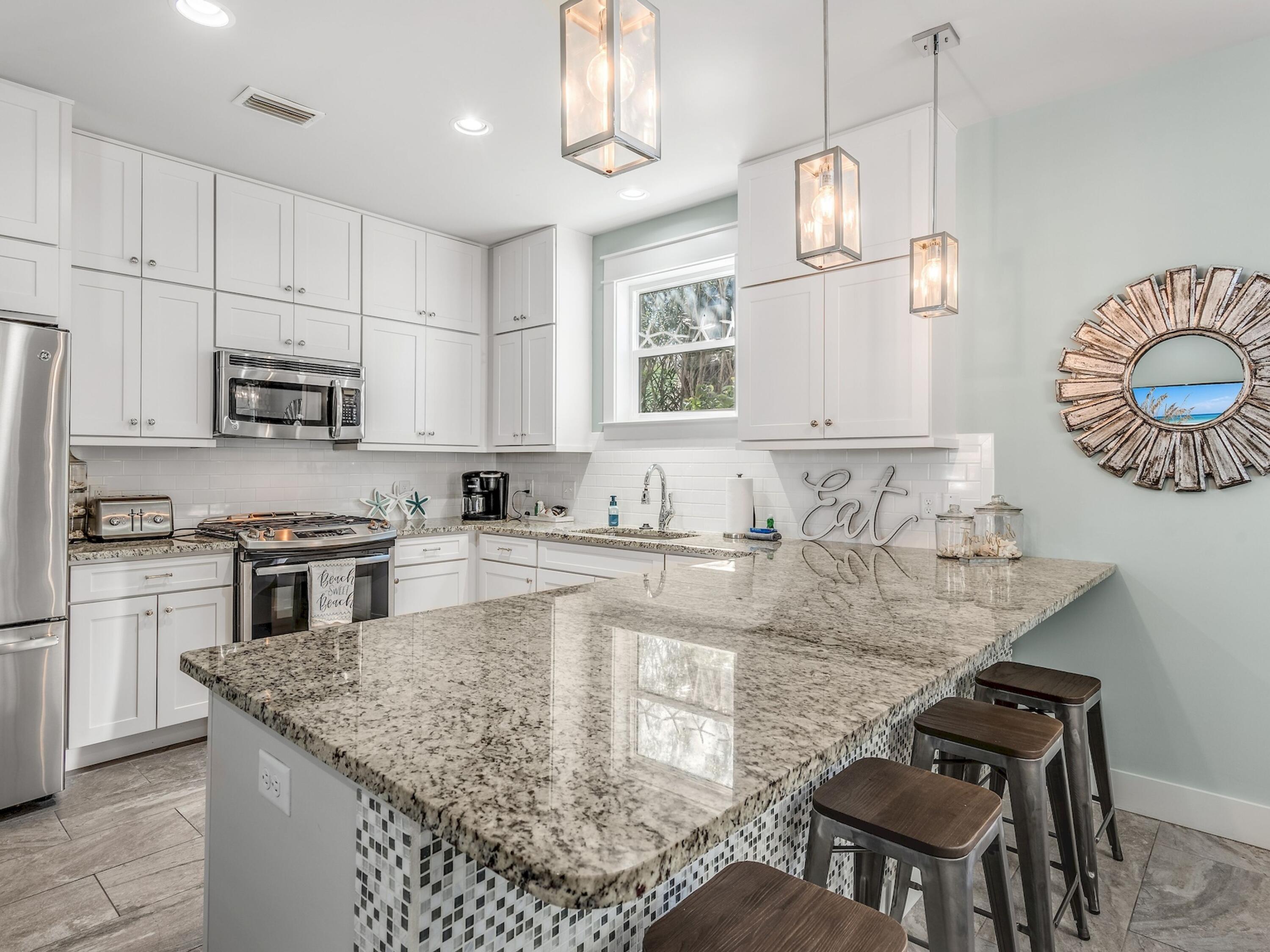77 Snapper Street Santa Rosa Beach, FL 32459 - Photo 14 of 54 a kitchen with kitchen island granite countertop a sink and a stove top oven