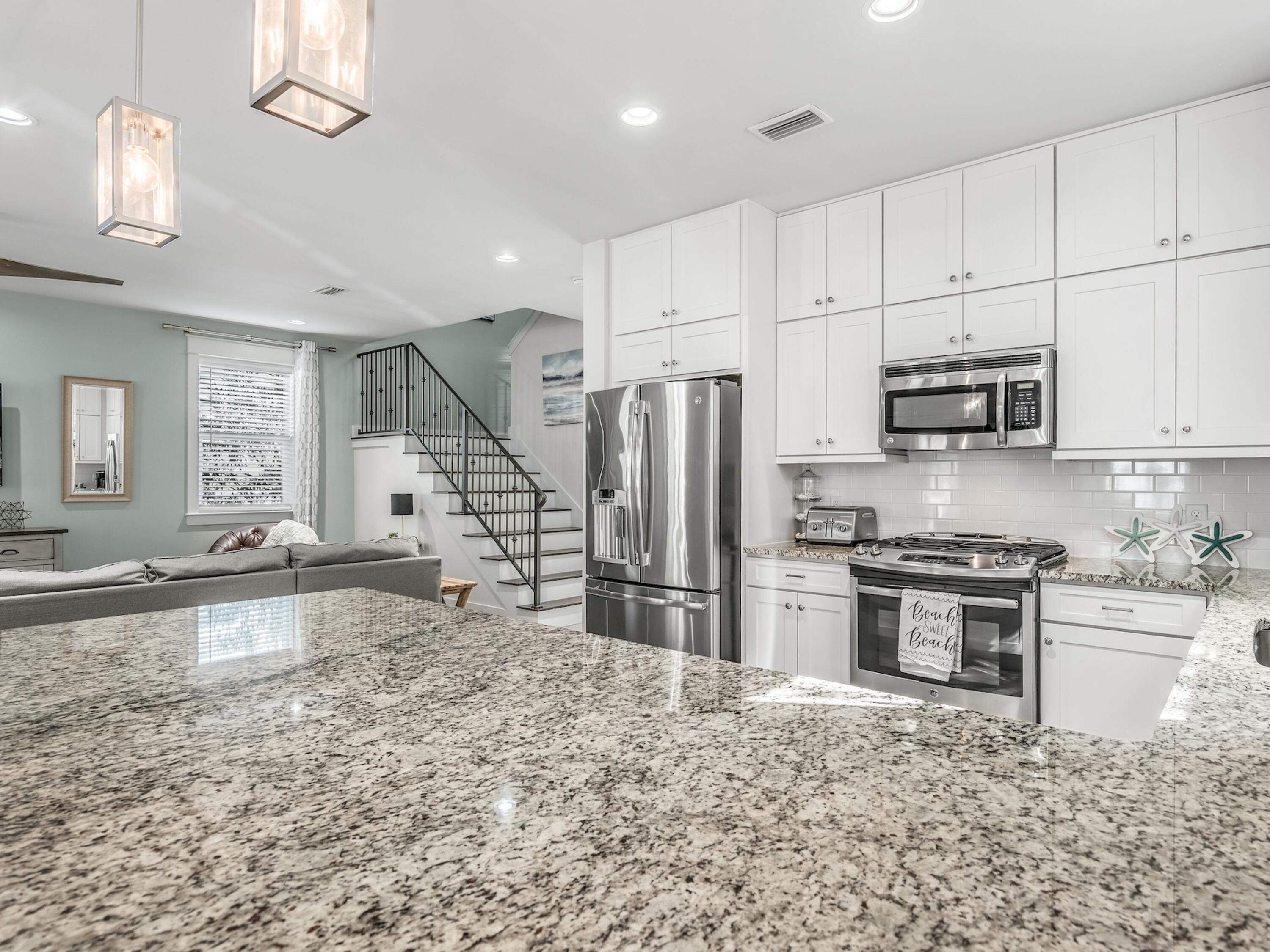 77 Snapper Street Santa Rosa Beach, FL 32459 - Photo 15 of 54 a kitchen with stainless steel appliances granite countertop a stove a sink a oven a refrigerator and white cabinets with wooden floor