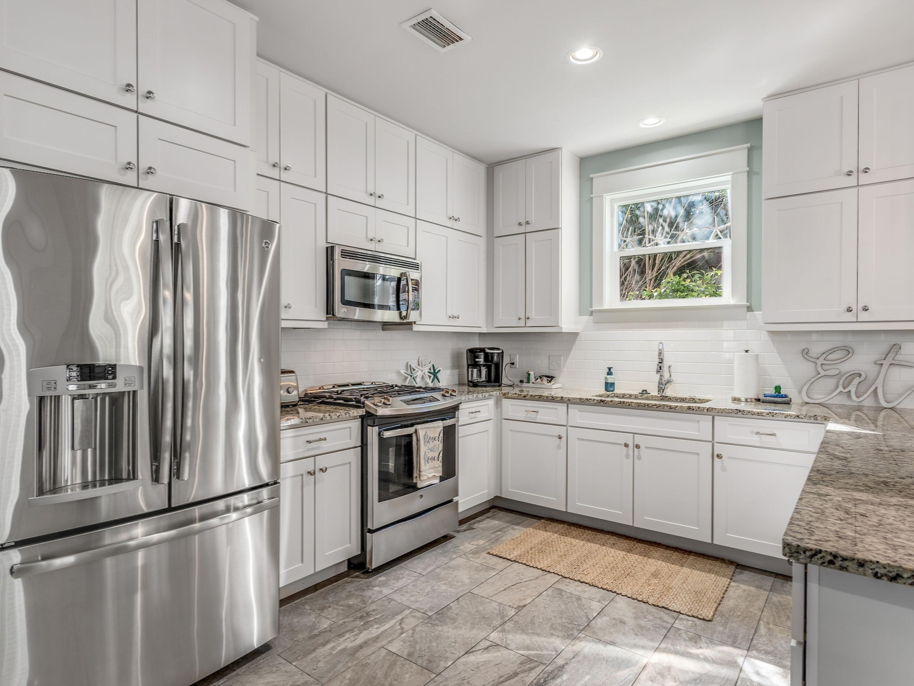 77 Snapper Street Santa Rosa Beach, FL 32459 - Photo 16 of 54 a kitchen with granite countertop white cabinets and stainless steel appliances