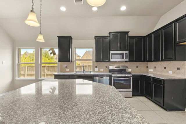 a kitchen with a sink a counter top space cabinets and stainless steel appliances