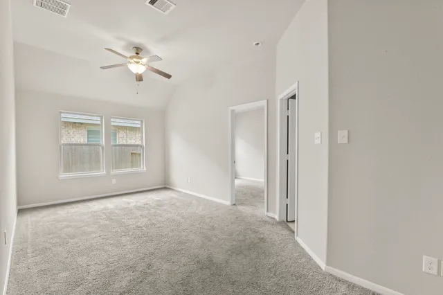 an empty room with closet and a chandelier fan