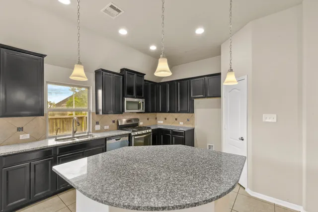 a kitchen with stainless steel appliances granite countertop a sink stove and refrigerator