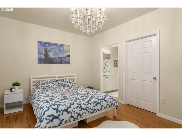 a bedroom with a bed and a painting on the wall