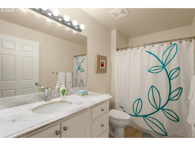a bathroom with a granite countertop sink a mirror a vanity and a shower