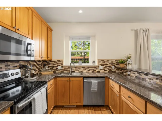 a kitchen with stainless steel appliances granite countertop a sink stove and cabinets