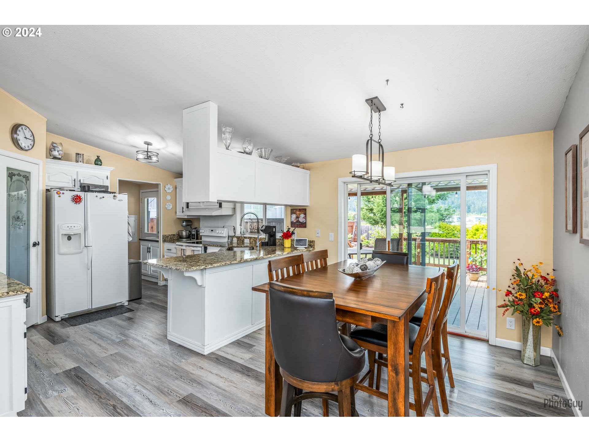 90640 Marcola Road Springfield, OR 97478 - Photo 10 of 40 a dining room with stainless steel appliances a dining table wooden floor and a chandelier