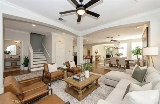 a view of an empty room with wooden floor and a ceiling fan