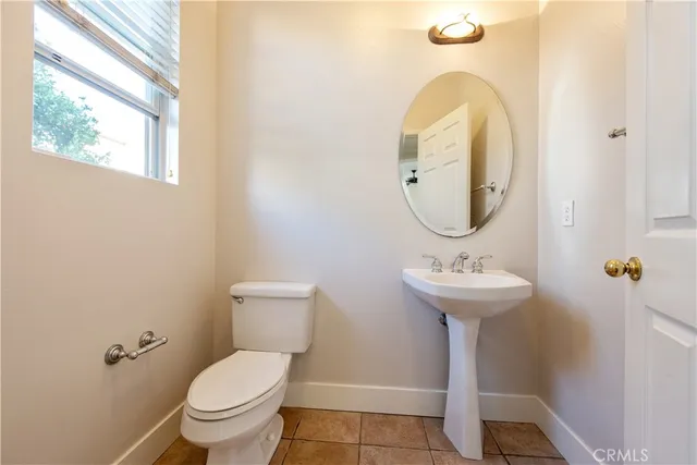 a view of an empty room and kitchen with wooden floor and a ceiling fan