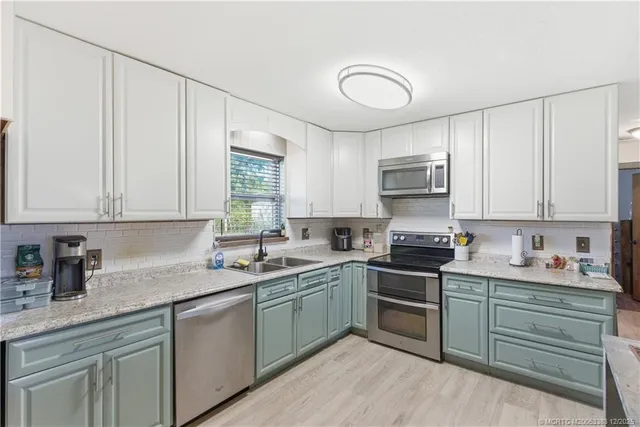 a kitchen with a sink stove and cabinets