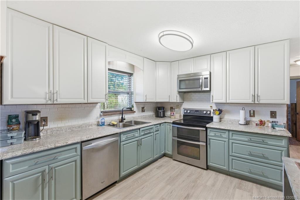 3031 Northwest 2nd Street Okeechobee, FL 34972 - Photo 11 of 19 a kitchen with a sink stove and cabinets
