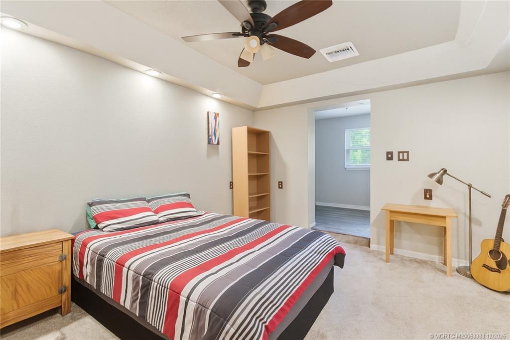 3031 Northwest 2nd Street Okeechobee, FL 34972 - Photo 14 of 19 a bedroom with a bed and a chandelier