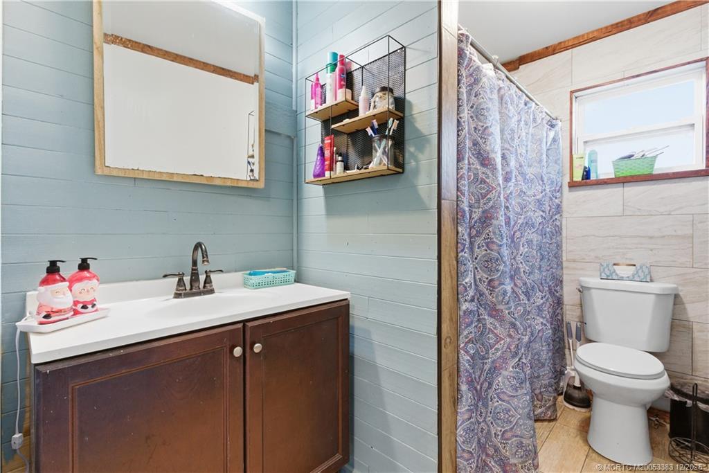 3031 Northwest 2nd Street Okeechobee, FL 34972 - Photo 15 of 19 a bathroom with a sink vanity mirror and toilet