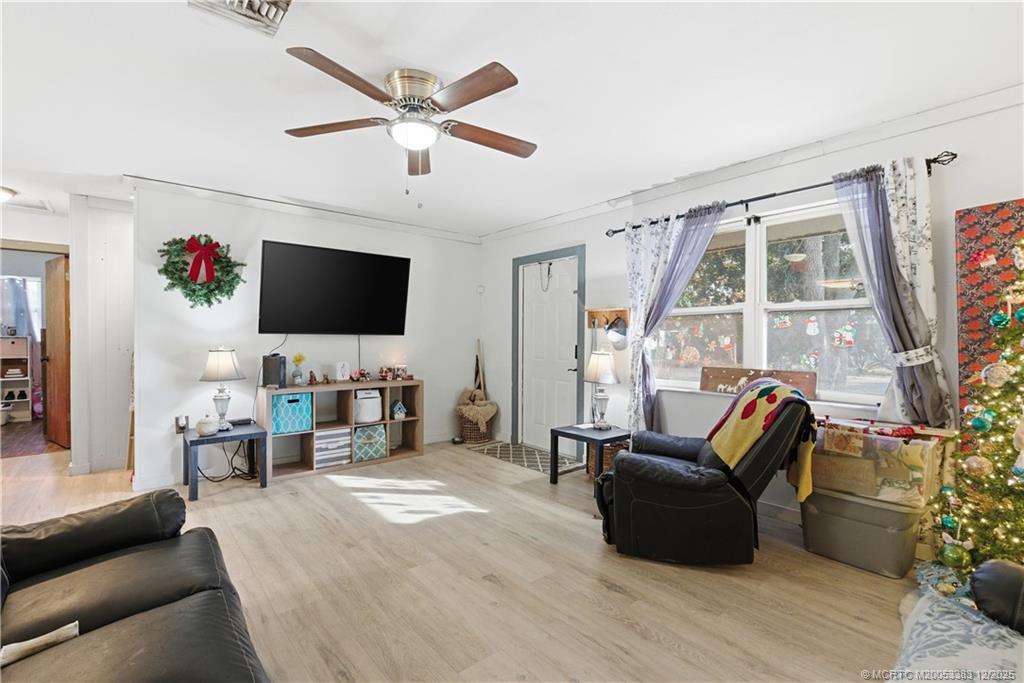 3031 Northwest 2nd Street Okeechobee, FL 34972 - Photo 6 of 19 a living room with furniture a flat screen tv and a large window
