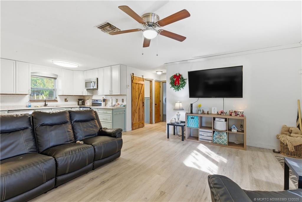 3031 Northwest 2nd Street Okeechobee, FL 34972 - Photo 7 of 19 a living room with furniture and a flat screen tv