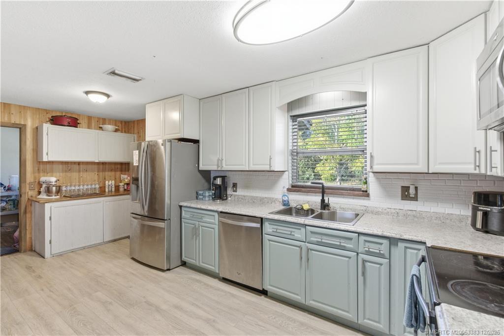 3031 Northwest 2nd Street Okeechobee, FL 34972 - Photo 10 of 19 a kitchen with a sink a refrigerator and cabinets
