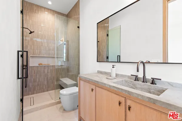 a bathroom with a granite countertop sink toilet and shower