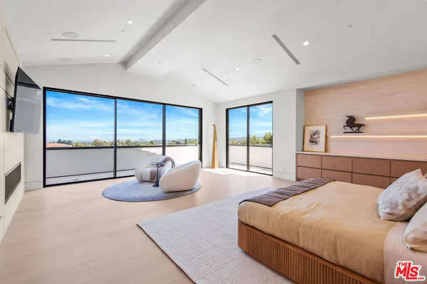 a bedroom with a large bed and a large window