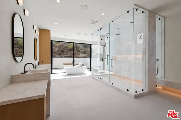 a spacious bathroom with a double vanity sink a mirror and a bathtub