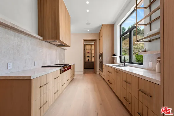 a large kitchen with stainless steel appliances granite countertop a lot of counter space and a sink
