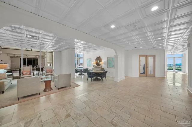 a living room with furniture and floor to ceiling windows