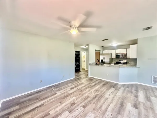 a view of an empty room and kitchen view