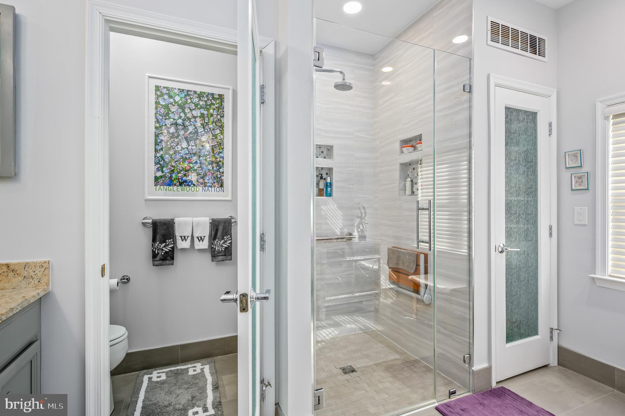 a bathroom with a glass door shower and a sink