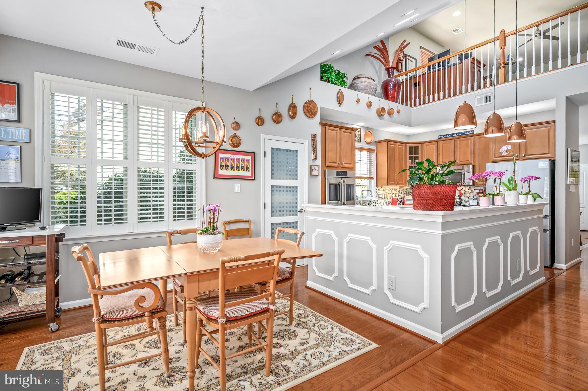 44550 Baltray Circle Ashburn, VA 20147 - Photo 18 of 44 a view of a dining room with furniture a chandelier and wooden floor