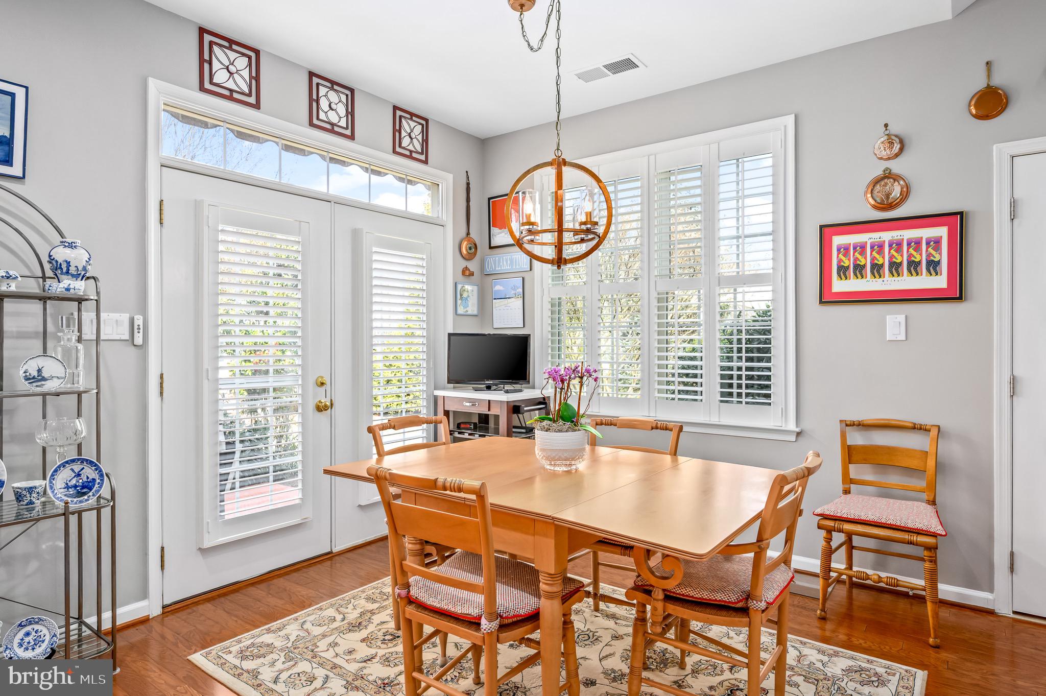 44550 Baltray Circle Ashburn, VA 20147 - Photo 19 of 44 a dining room with wooden floor a chandelier a wooden table and chairs