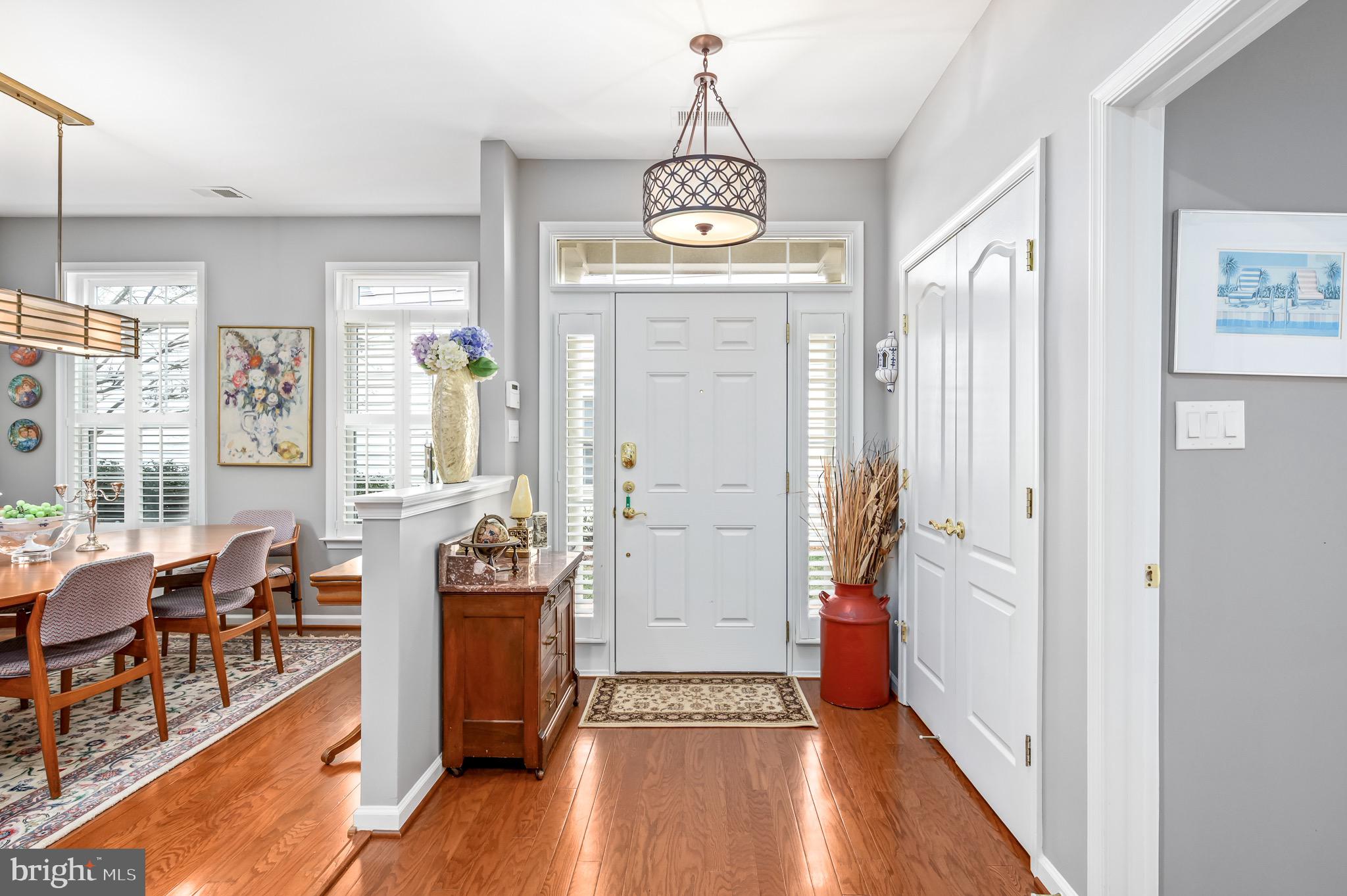 44550 Baltray Circle Ashburn, VA 20147 - Photo 7 of 44 a view of a hallway with wooden floor windows a chandelier and livingroom