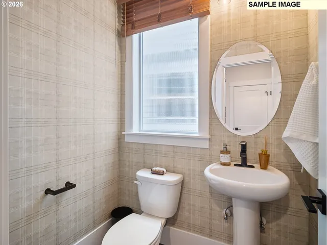 a bathroom with a toilet sink and mirror