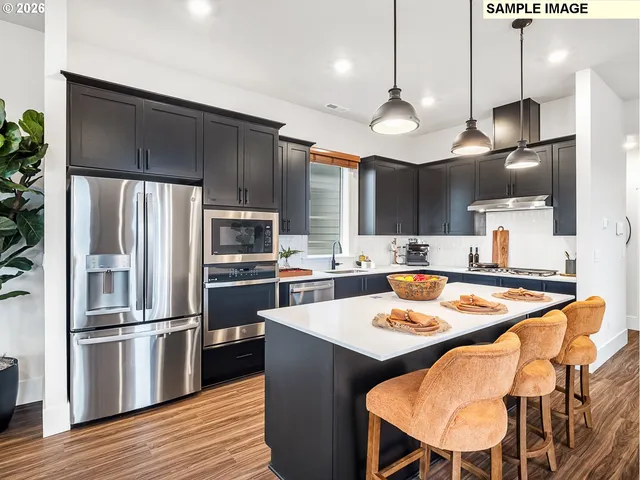 a kitchen with stainless steel appliances granite countertop a sink refrigerator and cabinets