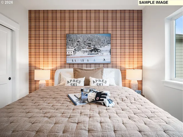 a bedroom with a bed and a large window