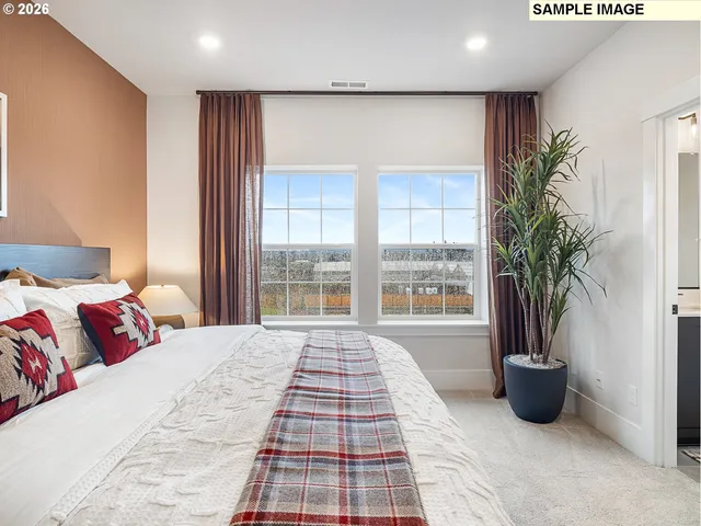 a bedroom with a bed and a potted plant