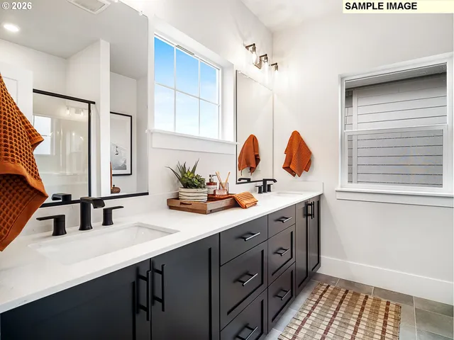 a en suite bathroom with a double vanity sink a mirror and shower