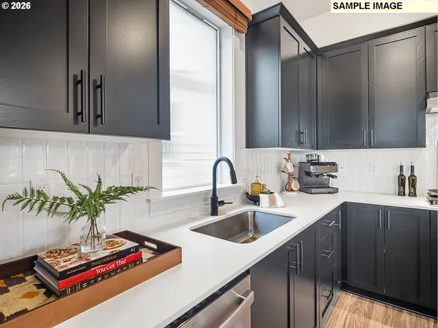 a kitchen with stainless steel appliances a sink a stove and a wooden cabinets