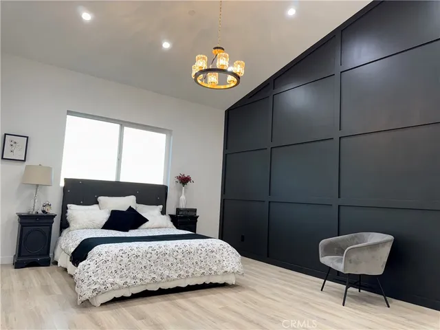 a bedroom with a bed and a chandelier