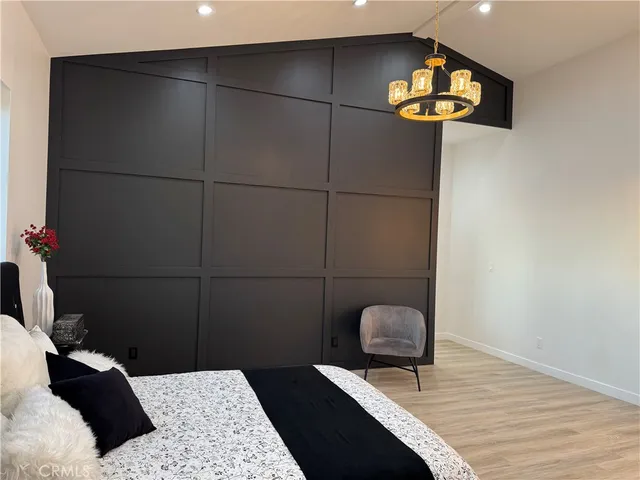 a bedroom with a bed and a potted plant on dresser