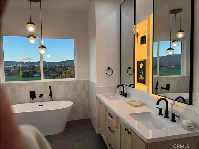 a bathroom with a tub sink and mirror