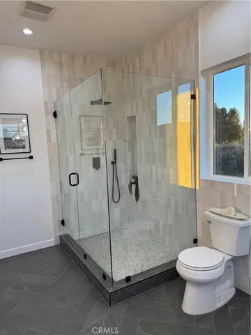 a bathroom with a toilet and a shower