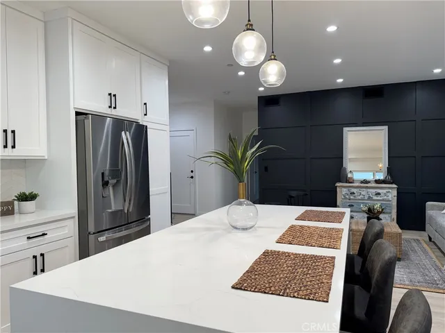 a kitchen with stainless steel appliances kitchen island granite countertop a refrigerator and a stove top oven