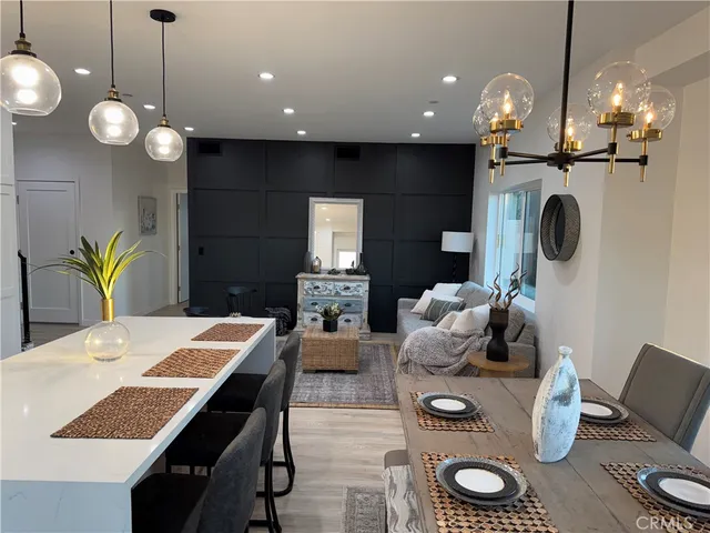 a dining room filled chandelier and kitchen view