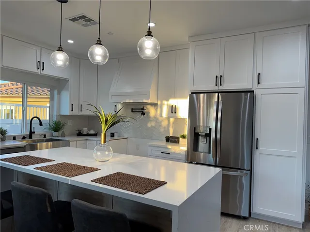 a kitchen with stainless steel appliances granite countertop a sink refrigerator and cabinets