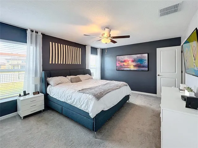 a spacious bedroom with a bed and a chandelier