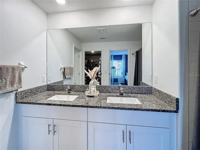 a bathroom with a granite countertop sink and a mirror
