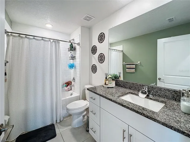 a spacious bathroom with a granite countertop sink toilet and shower