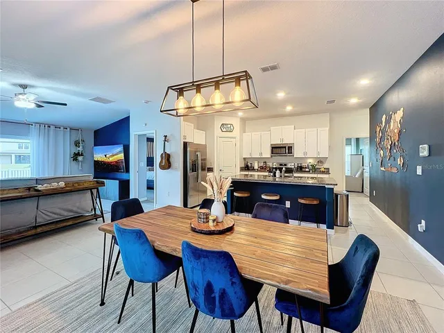 a kitchen with stainless steel appliances granite countertop a kitchen island a table and chairs