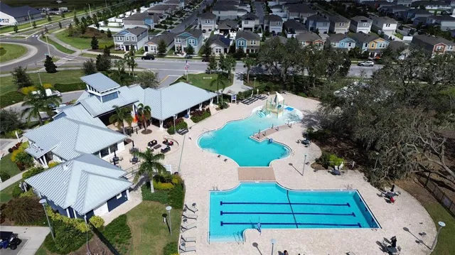 an aerial view of a house with a yard and lake view