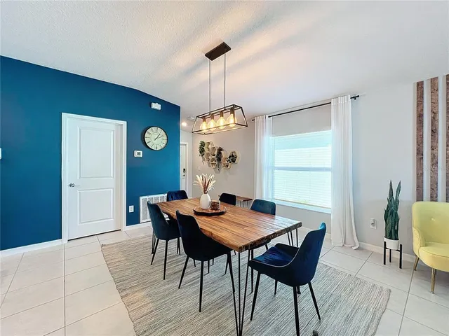 a dining room with furniture a chandelier and wooden floor